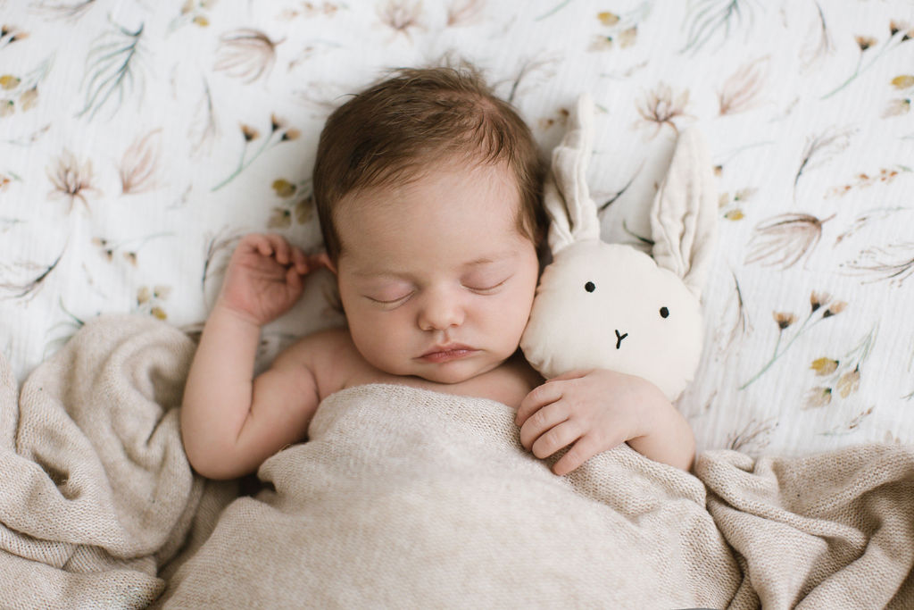 Baby mit kuscheltier Hase